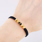 Pulsera Tejida Hilo Negro 4 Balines Lisos y Un Neoro Oro Amarillo 18K