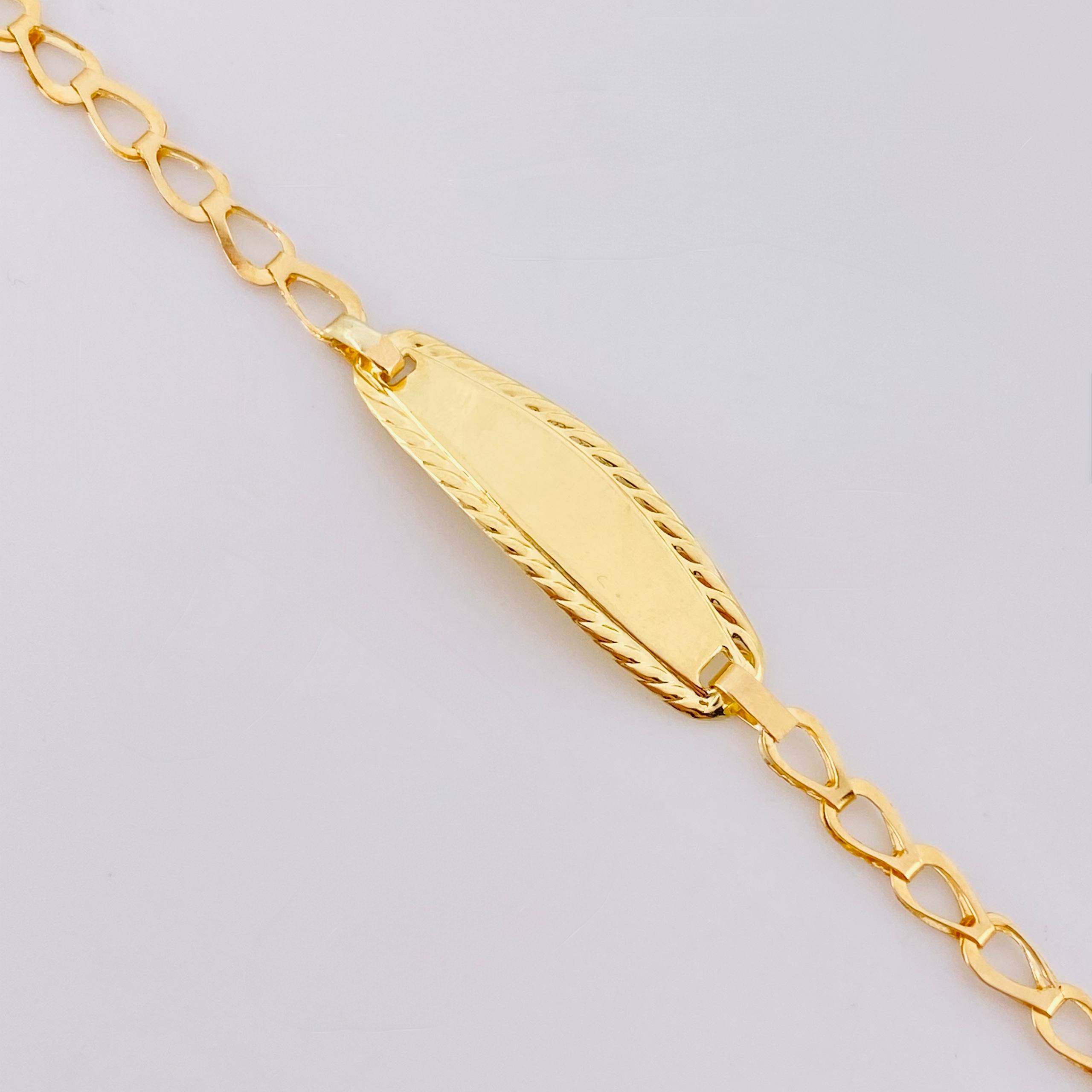 Pulso Bebé Espiga Placa Ovalada Bordeada 1.2gr / 5 3/4 in / 2.7mm Oro Amarillo 18K ©
