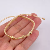 Pulsera Tejida Beige Cruz Maraquera Oro Amarillo 18K