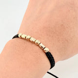 Black Woven Bracelet with Alternating Cylinders and Diamond Cut Beads in 18K Yellow Gold